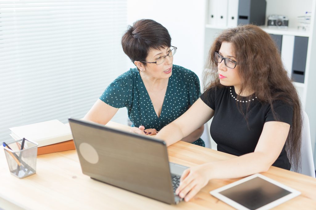 Two women sat at laptop discussing Things Small Online Retailers Need