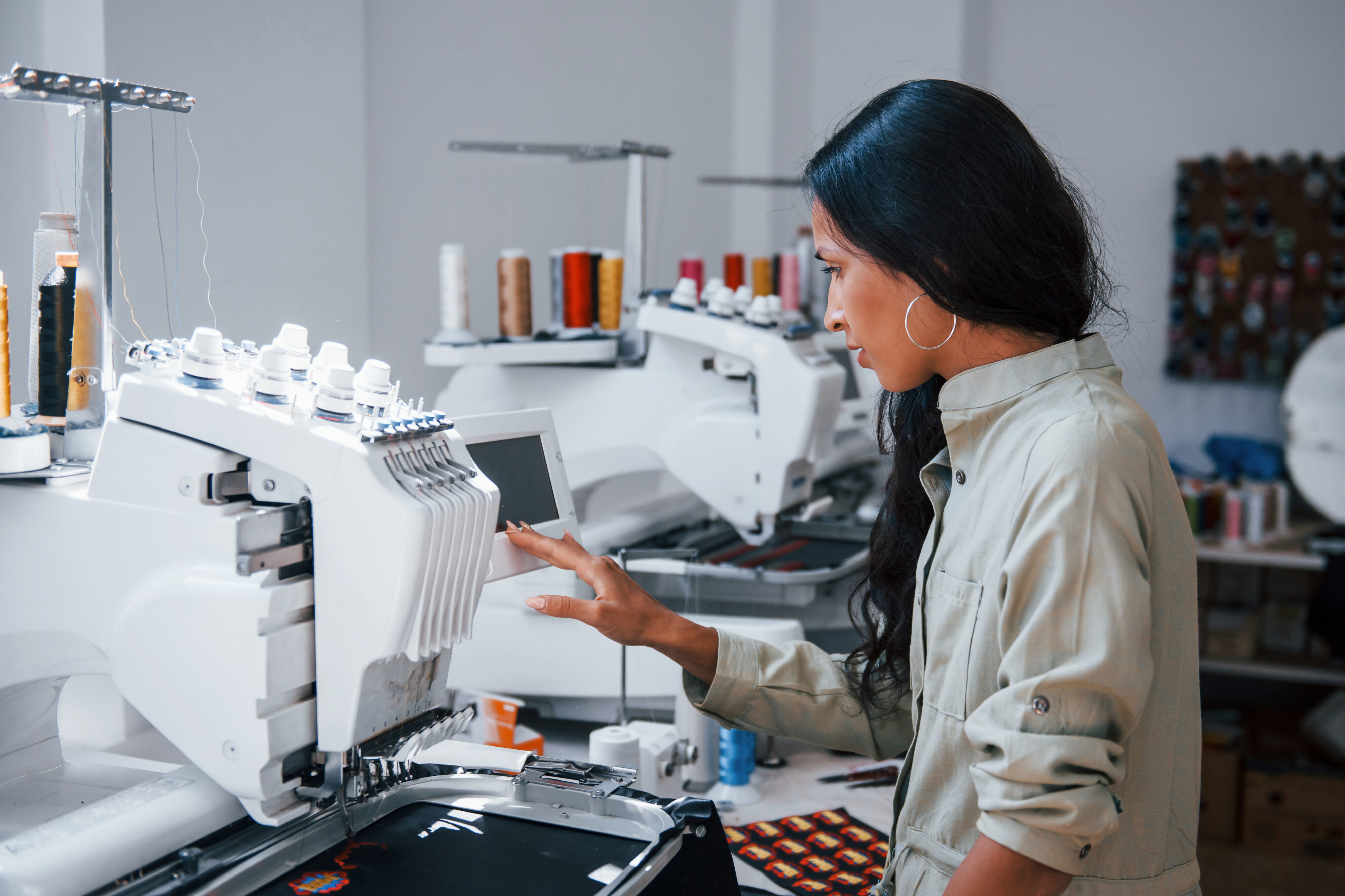 Beautiful female worker in a sewing factory, by the machine. Learning how machine vision imaging can help your business