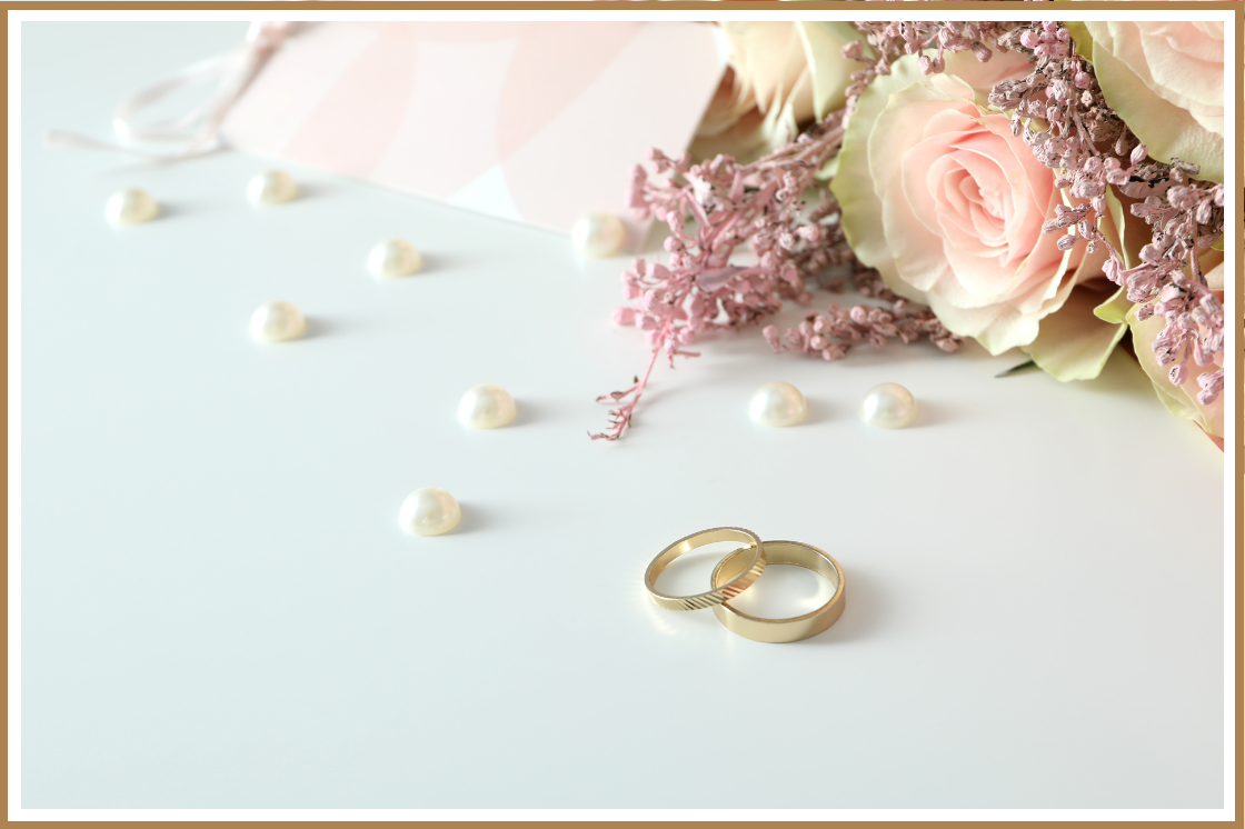 a pair of gold rings next to a bouquet of flowers - unique wedding gift ideas